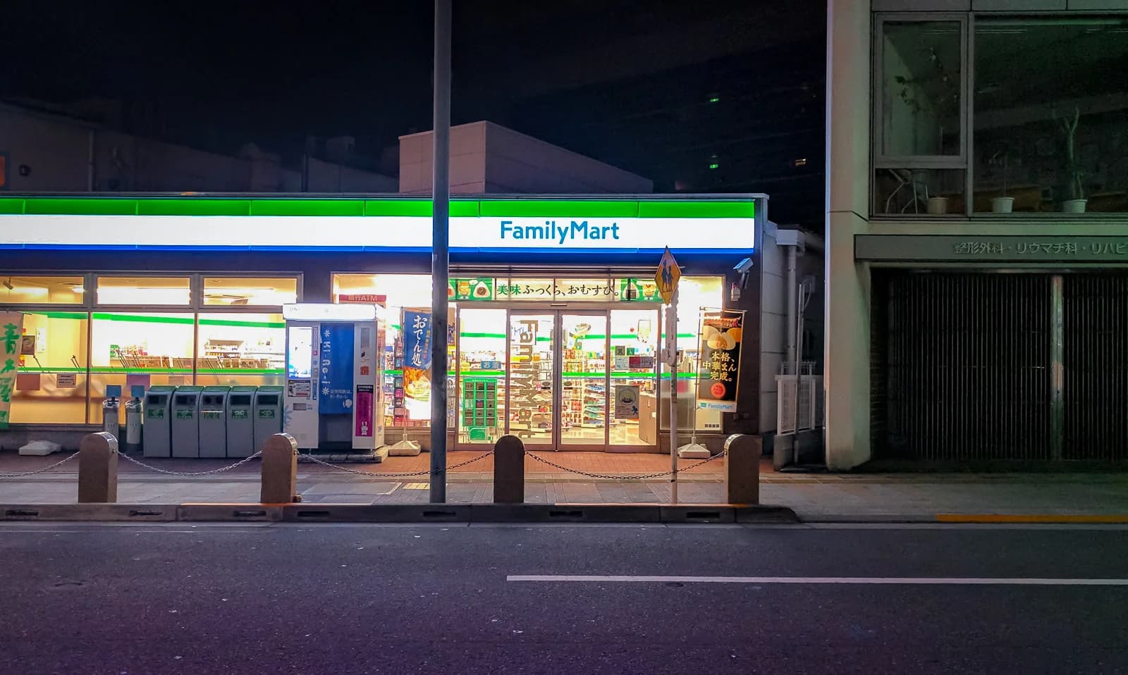 Verlichte gevel van een Japanse FamilyMart-gemakswinkel in de avond